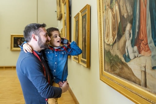 Père et fils utilisant des audioguides dans un musée