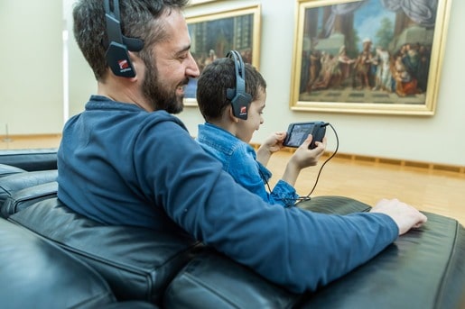 Father and son using orpheo touch audioguide in a museum